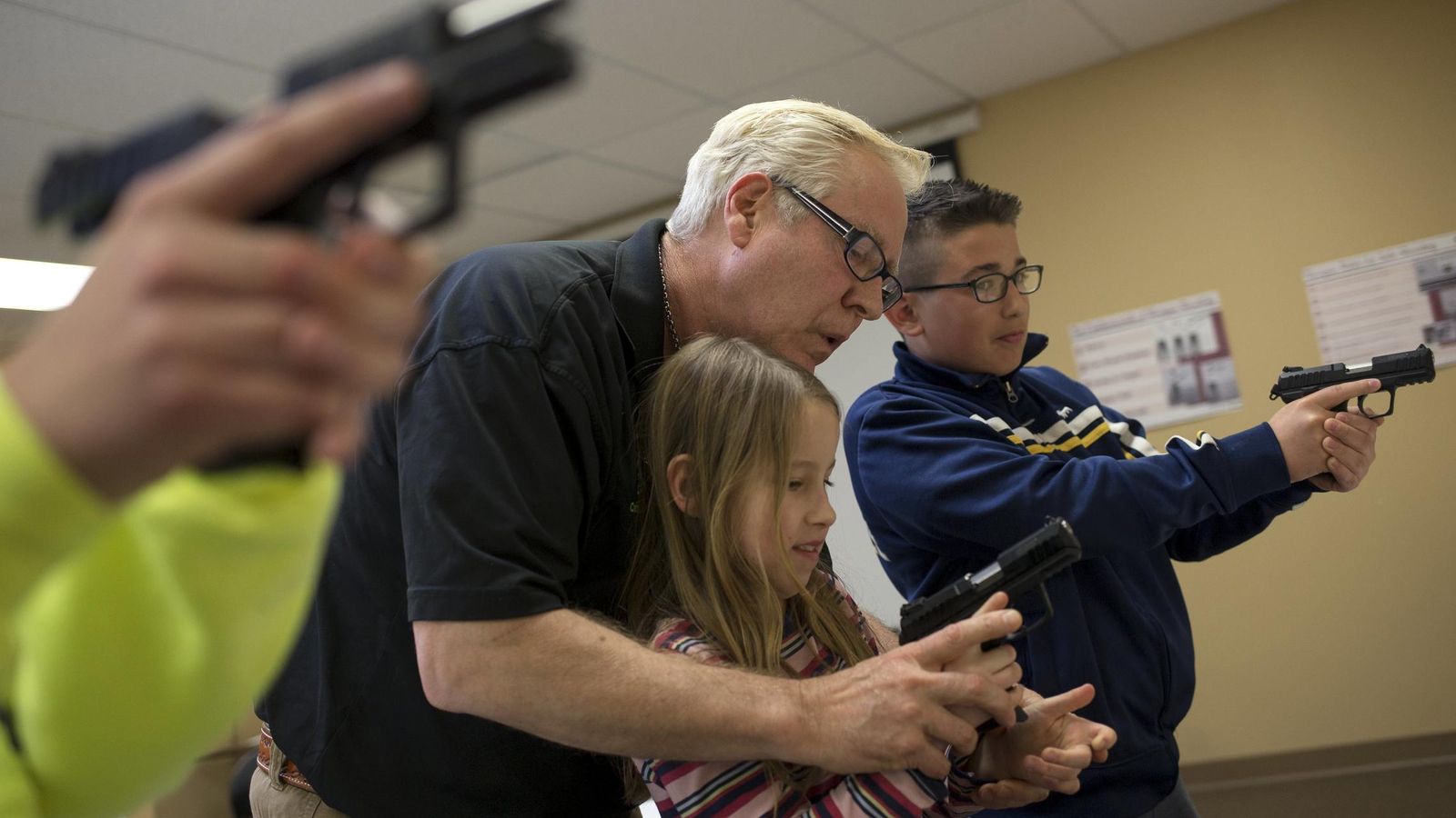 Foto: El instructor Jerry Kau enseña a la niña Joanna Zuber cómo sujetar un arma en East Dundee, Illinois (Reuters). 