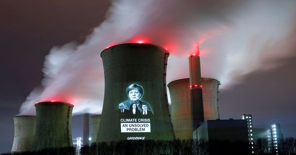 Foto: Activistas proyectan la imagen de la canciller Ángela Merkel en una central termoeléctrica. (EFE)