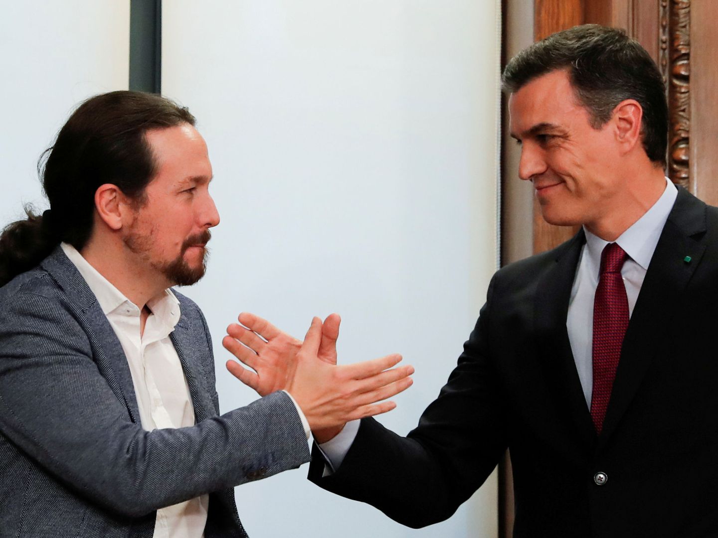Pablo Iglesias y Pedro Sánchez se saludan tras la firma del acuerdo. (Reuters)