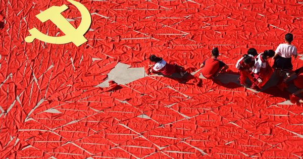 Foto: Estudiantes chinos utilizan alfombras rojas para formar una bandera antes del Congreso Nacional del PCCh, en Linyi, provincia de Shandong. (Reuters)