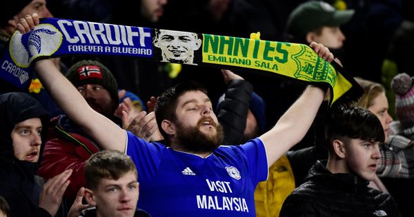 Foto: Un aficionado del Cardiff muestra una bufanda con la cara de Emiliano Sala. (Reuters)