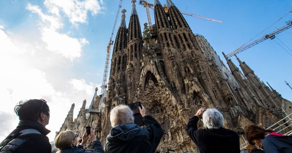 Foto: Un grupo de turistas extranjeros admira la fachada de la Sagrada Familia en Barcelona. (EFE)