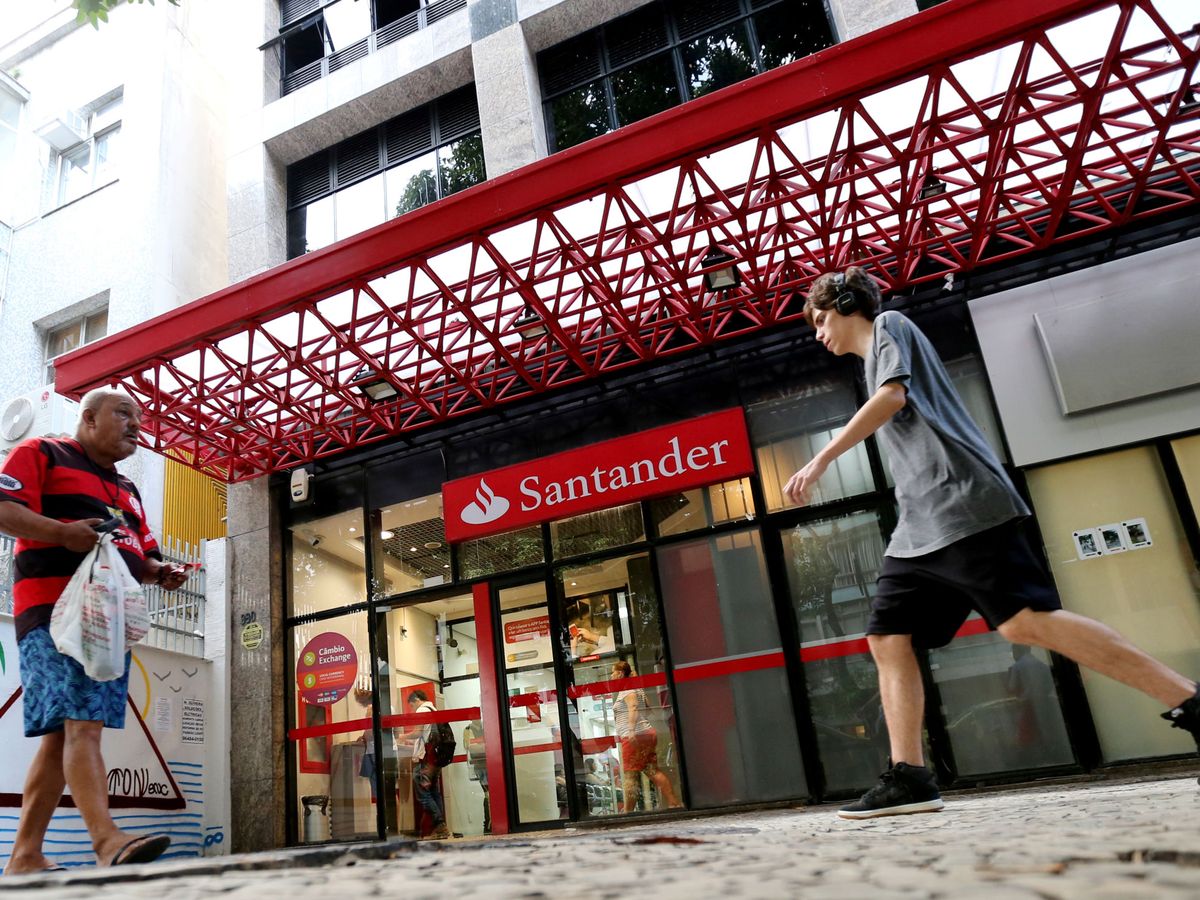 Foto: Dos personas caminan frente a una sucursal de Santander en Río de Janeiro. (Reuters)
