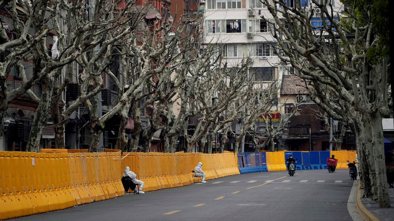Foto: Guardias con traje protector vigilan las barricadas de una zona confinada en Shanghái. (Reuters/Aly Song)
