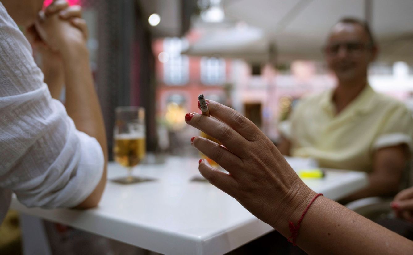 Una mujer sostiene un cigarrillo en la terraza de en un bar en Santa Cruz de Tenerife. (EFE/Miguel Barreto)