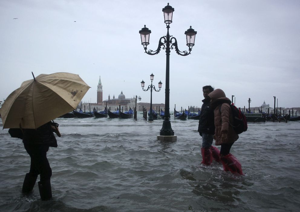 Foto: Varias personas caminan por las calles inundadas de Venecia tras unos días de fuertes lluvias en noviembre de 2012. (Reuters)