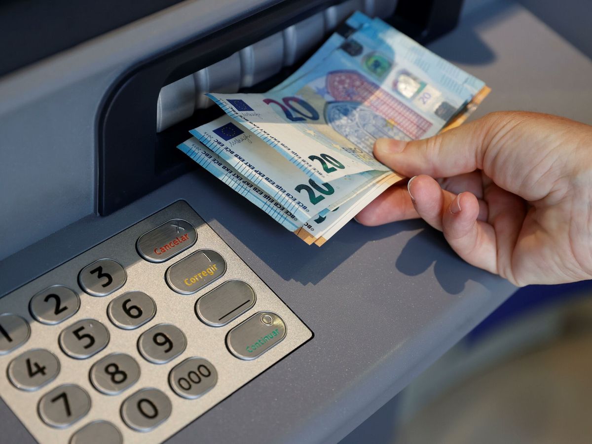 Foto: Una persona saca dinero del cajero de un banco. (EFE/Emilio Naranjo) 