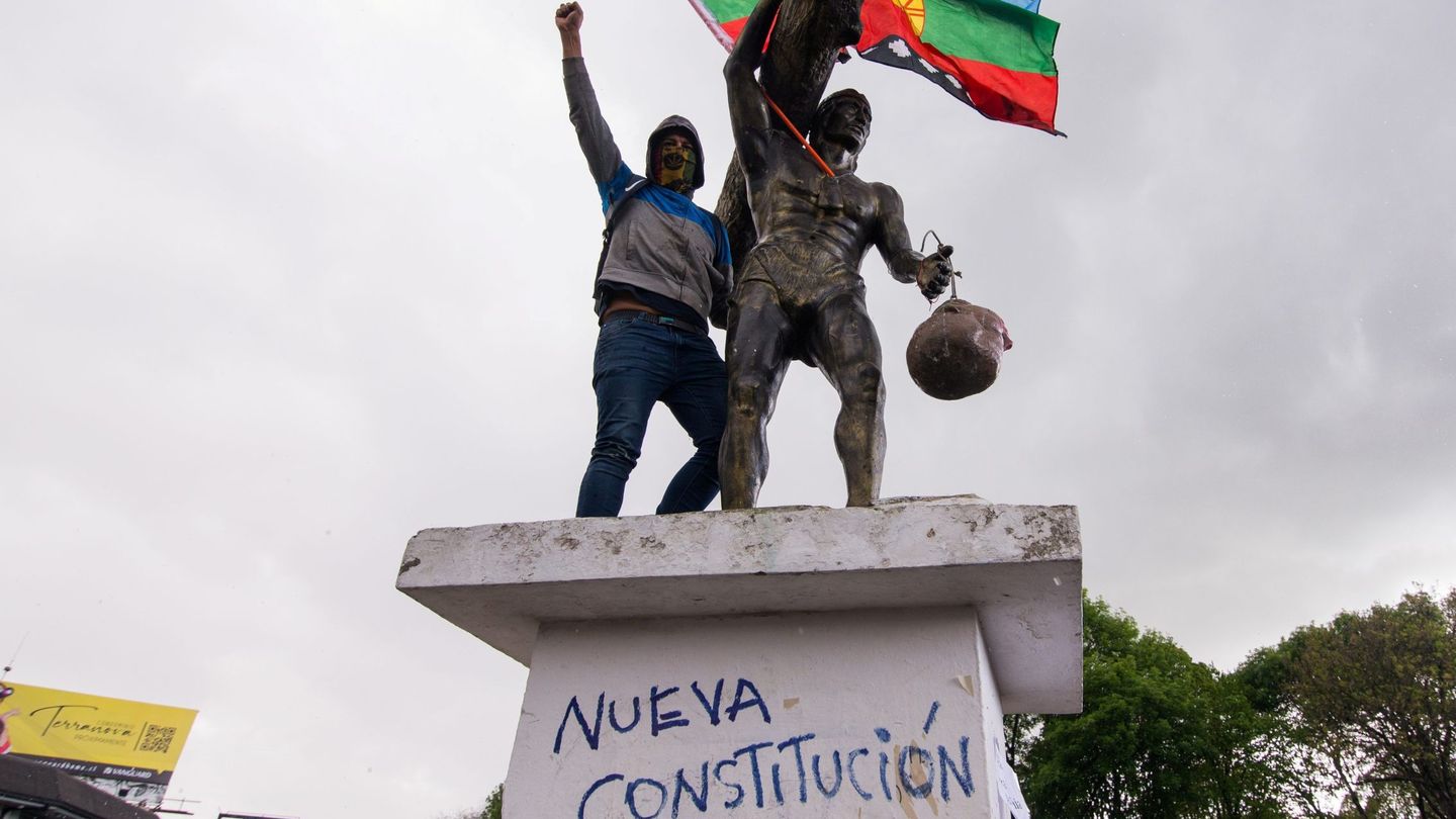 Un manifestante protesta durante el estallido social de 2019 junto a la estatua de Caupolicán, líder de la resistencia Mapuche, a la cual simbólicamente le pusieron la cabeza del busto de Pedro de Valdivia, militar y conquistador español. (EFE)