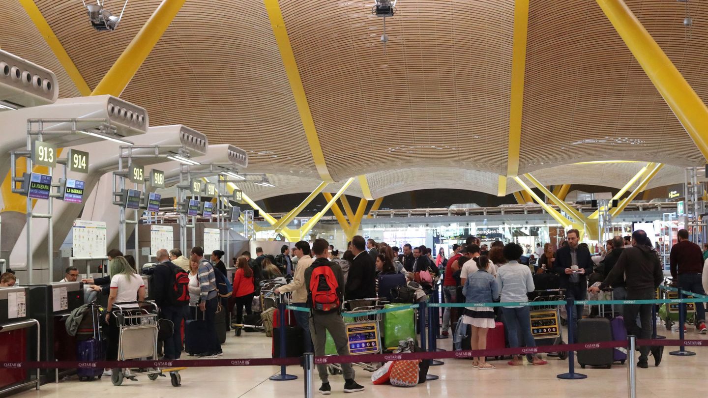 Pasajeros hacen cola ante los terminales de facturación del aeropuerto de Barajas de Madrid. (EFE)