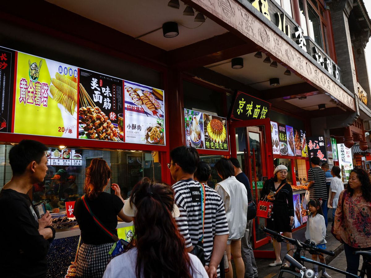 Foto: Personas delante de un restaurante en una calle de Beijing, China. Foto: Efe