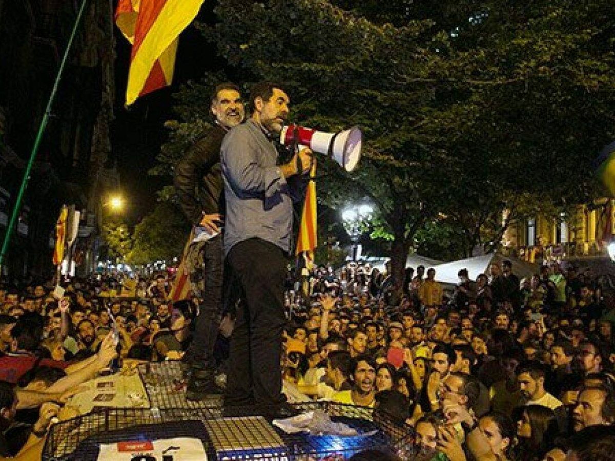 Foto: Jordi Sánchez y Jordi Cuixart sobre un coche de la Guardia Civil durante los sucesos de octubre de 2017 en Barcelona. (EFE)