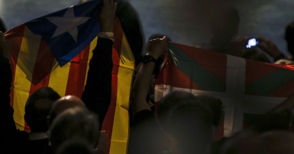 Foto: Varias personas portan una 'estelada' y una ikurriña durante una conferencia en San Sebastián sobre el 'procés'. (EFE)