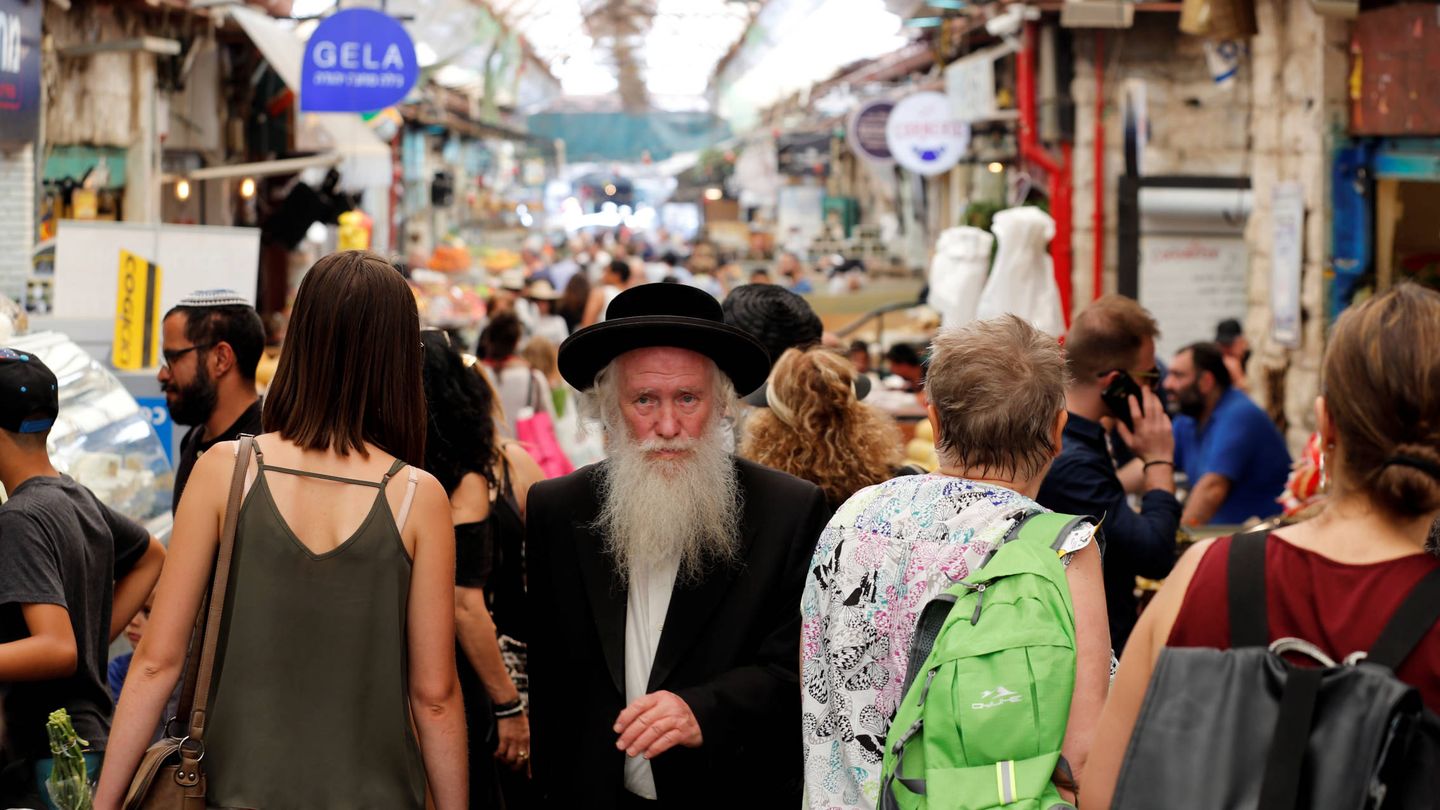 Un judío ultraortodoxo camina entre israelíes laicos por un mercado de Jerusalén. (Reuters) 