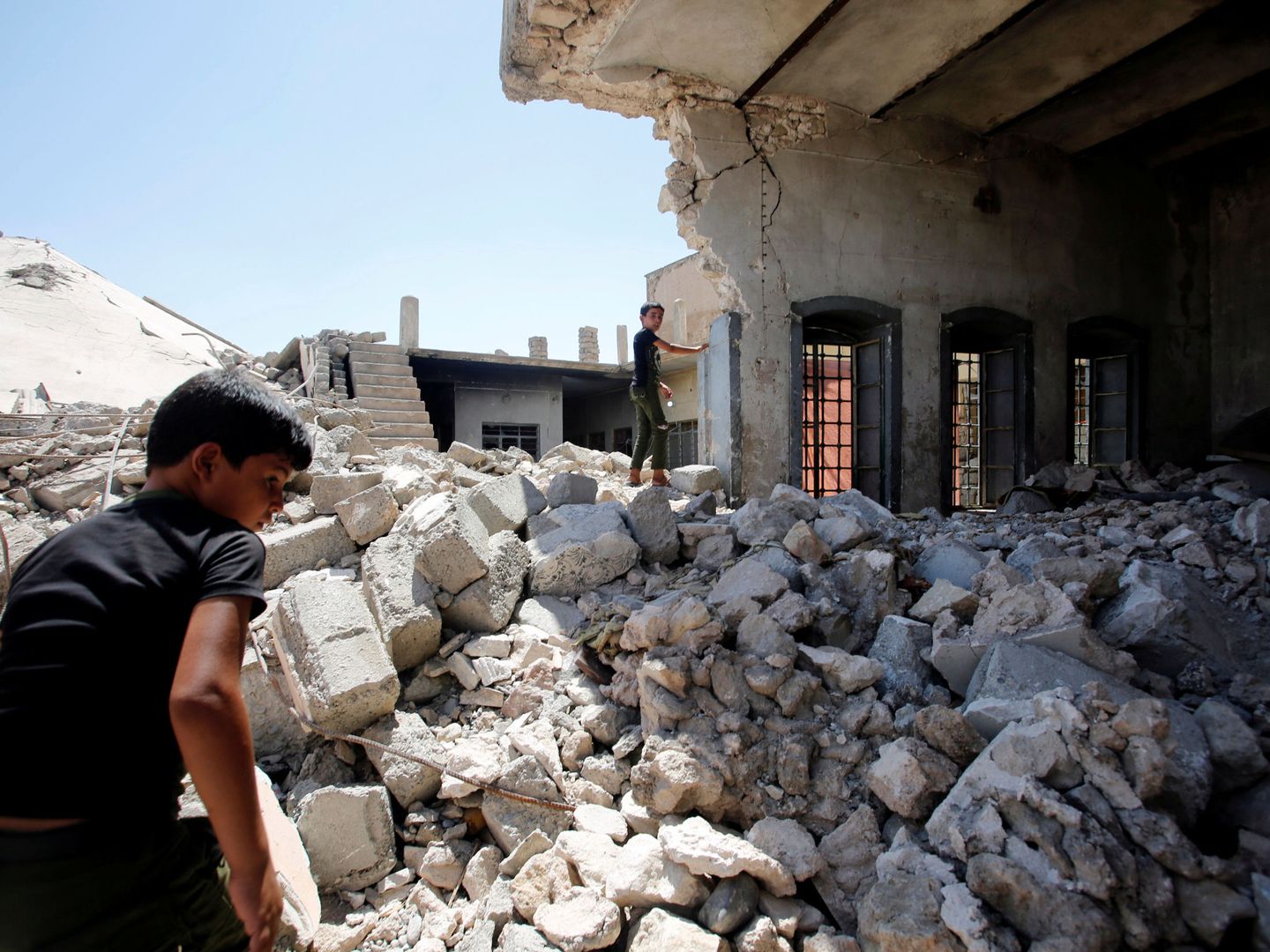 Varios niños escalan los escombros de su antigua casa en Mosul, en agosto de 2018. (Reuters)