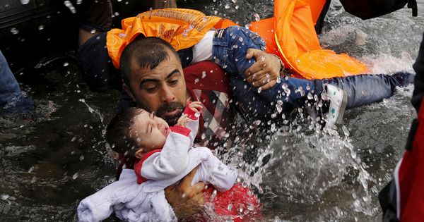 Foto: Un refugiado sirio sostiene a su hijo en su trayecto hasta la isla de Lesbos en 2015. (Reuters)