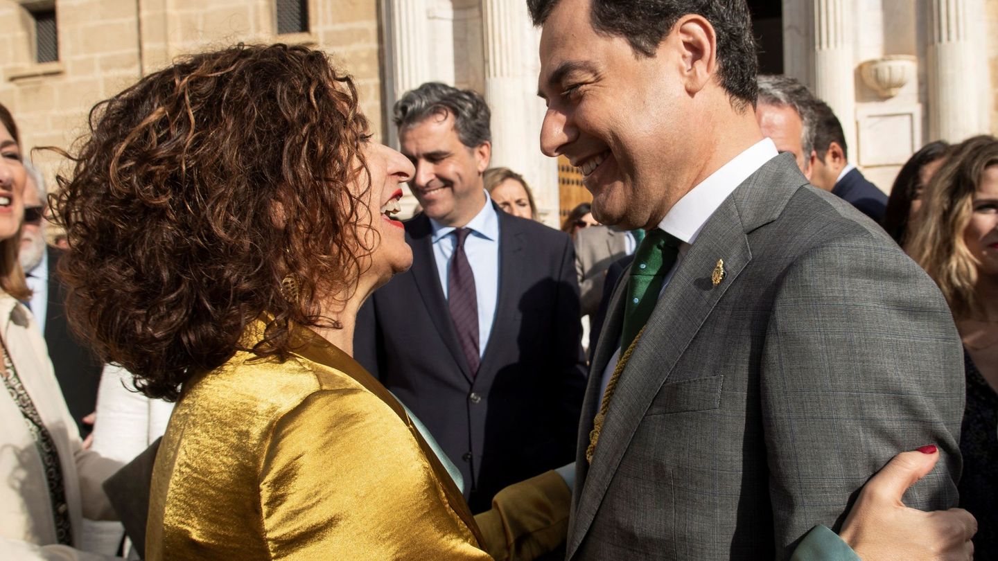 La ministra de Hacienda y portavoz del Gobierno de España, María Jesús Montero (i), saluda al presidente andaluz, Juanma Moreno (d), en una imagen de febrero de 2020. (EFE)