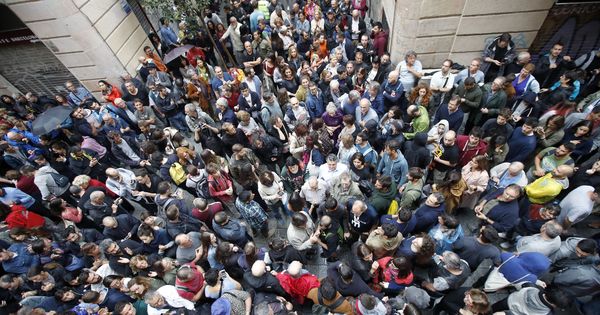 Foto: Numerosas personas esperan a las afueras del colegio Cervantes de Barcelona el 1-O. (EFE)