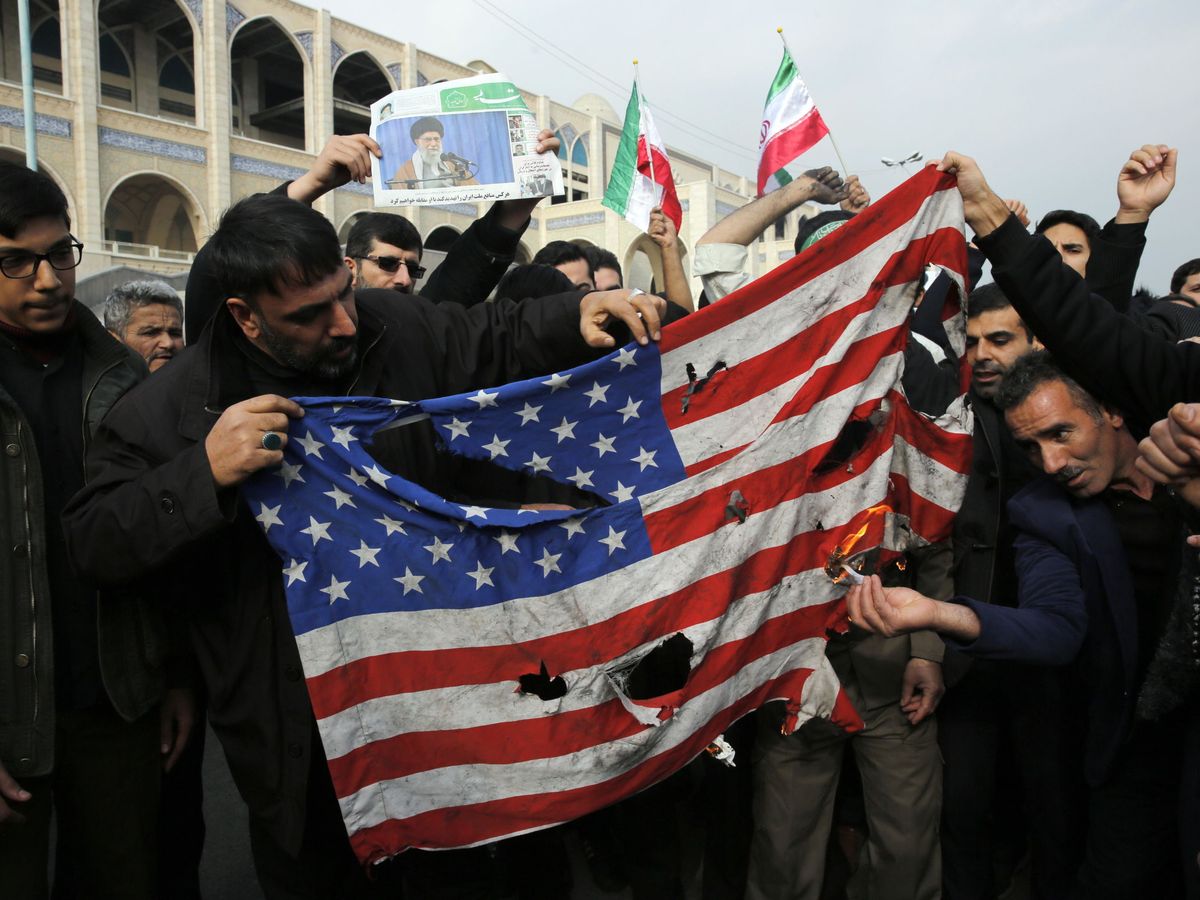 Foto: Manifestantes iraníes rompiendo una bandera de Estados Unidos. (Reuters)