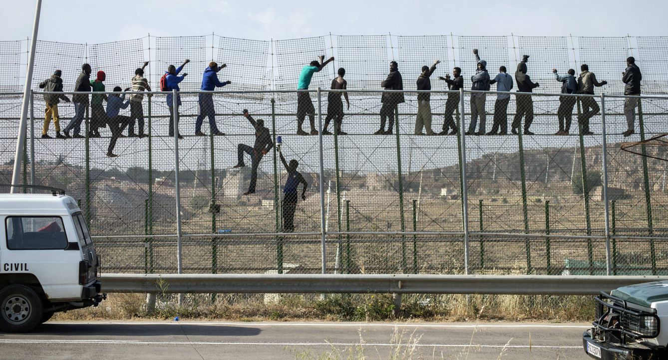Foto: Migrantes africanos encaramados a la valla de Melilla tras intentar entrar en territorio español, en mayo de 2014 (Reuters).