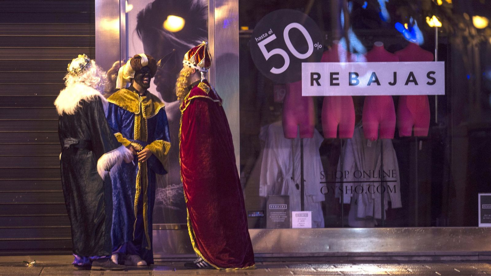 Foto: Tres hombres disfrazados de Reyes Magos, junto al escaparate de una tienda en Córdoba (EFE)