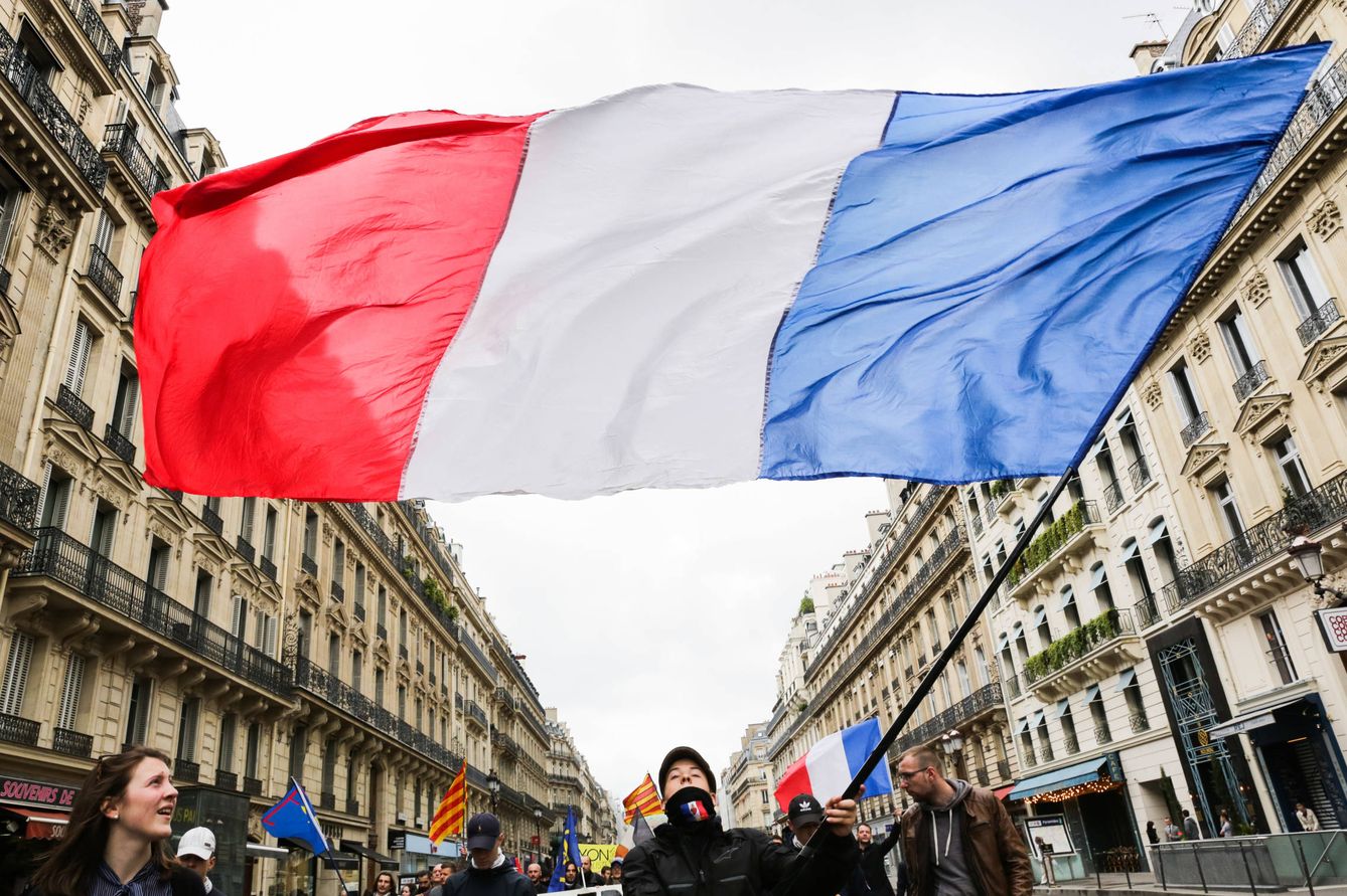 Un joven recorre la marcha con una enorme bandera francesa. (T. S.)