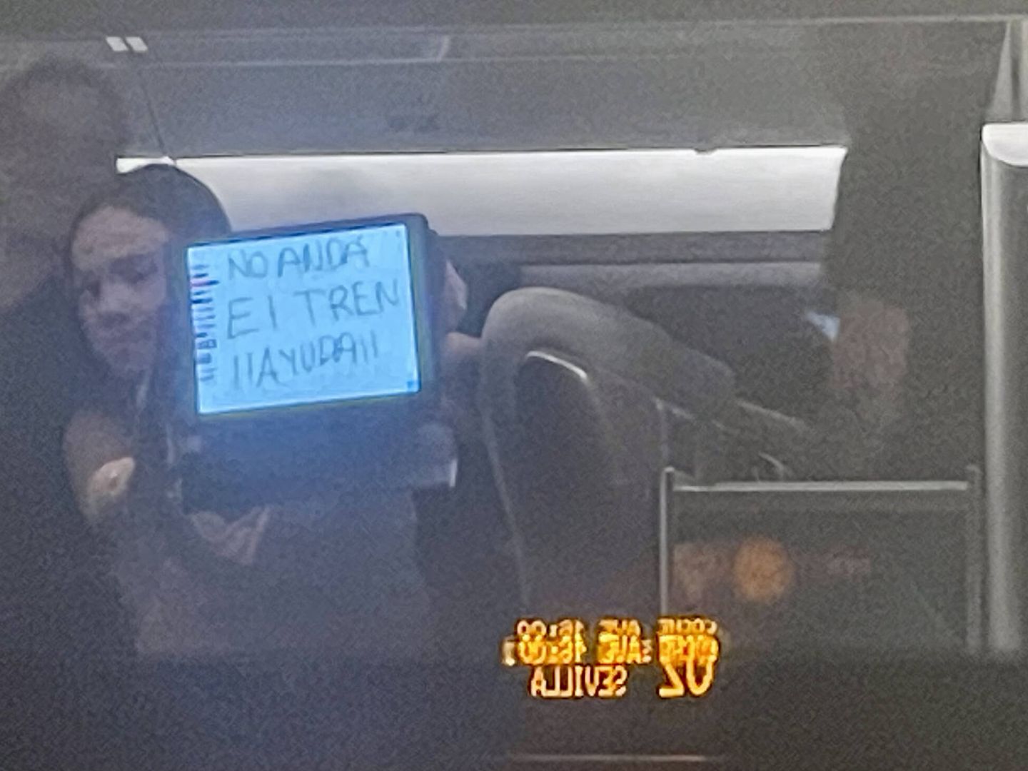 Una pasajera pide auxilio con un cartel en su tableta.
