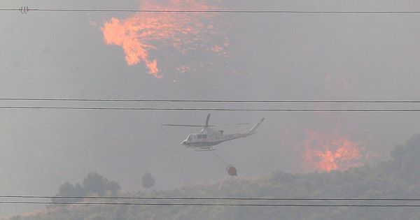 Foto: Un helicóptero trabaja en el incendio forestal en el barranco de Beneixama. (EFE)