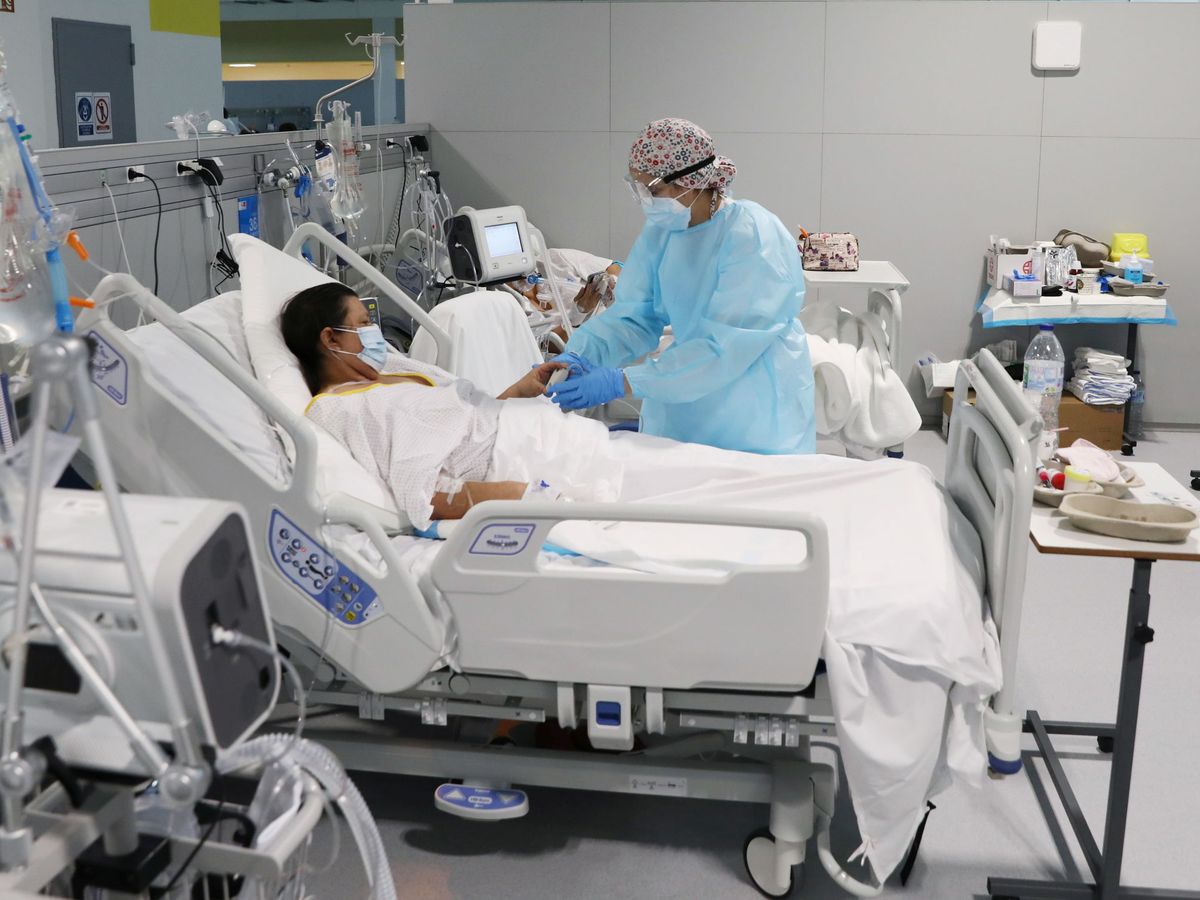 Foto: Una médica atiende a una paciente con coronavirus en el Hospital Isabel Zendal de Madrid. (Reuters)