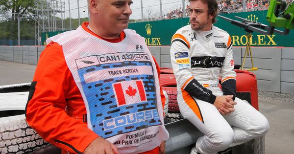 Foto: Alonso, sentado este viernes junto a un comisario tras sufrir otro problema mecánico. (EFE)