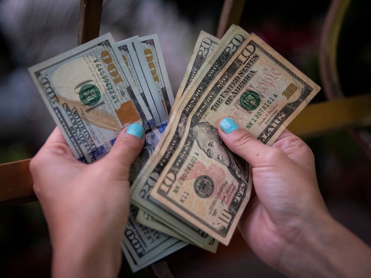 Foto: Una mujer muestra billetes de dólar en Caracas. (EFE) 