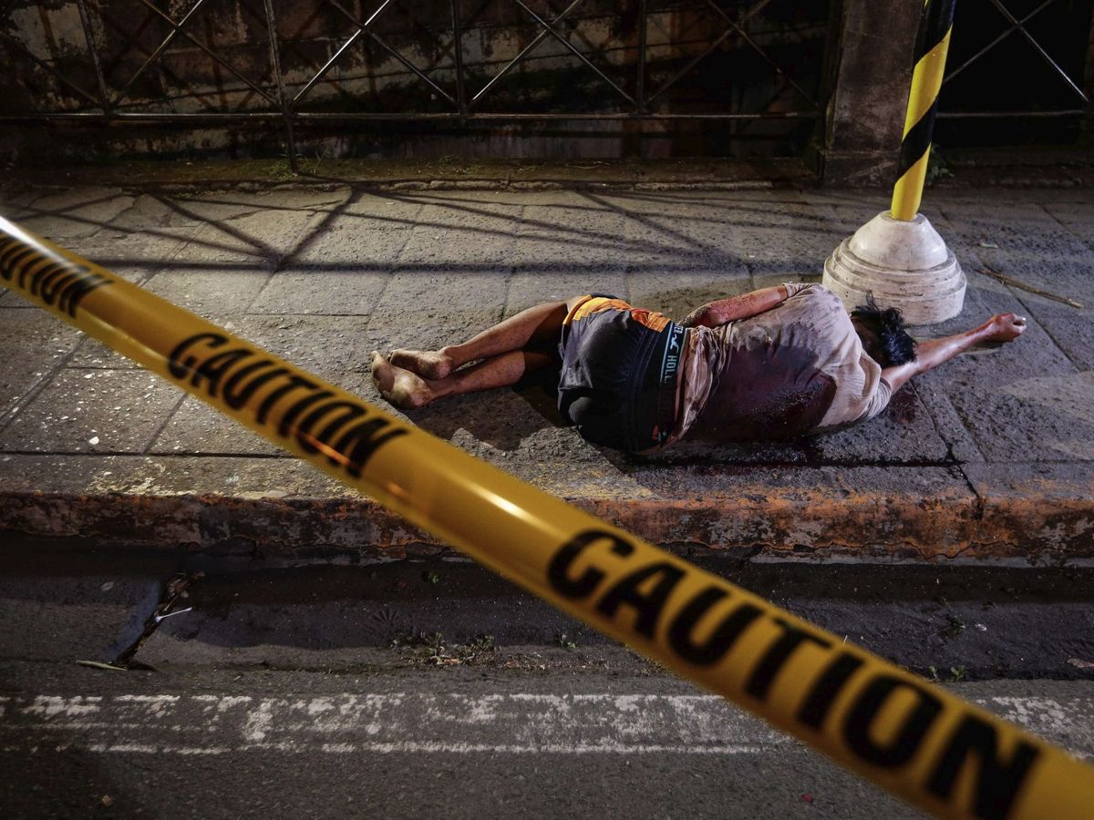 Foto: Un individuo, supuestamente implicado en el consumo o tráfico de drogas, yace en el suelo tras ser asesinado la pasada Nochebuena por un pistolero no identificado, en Manila (Filipinas). (EFE)