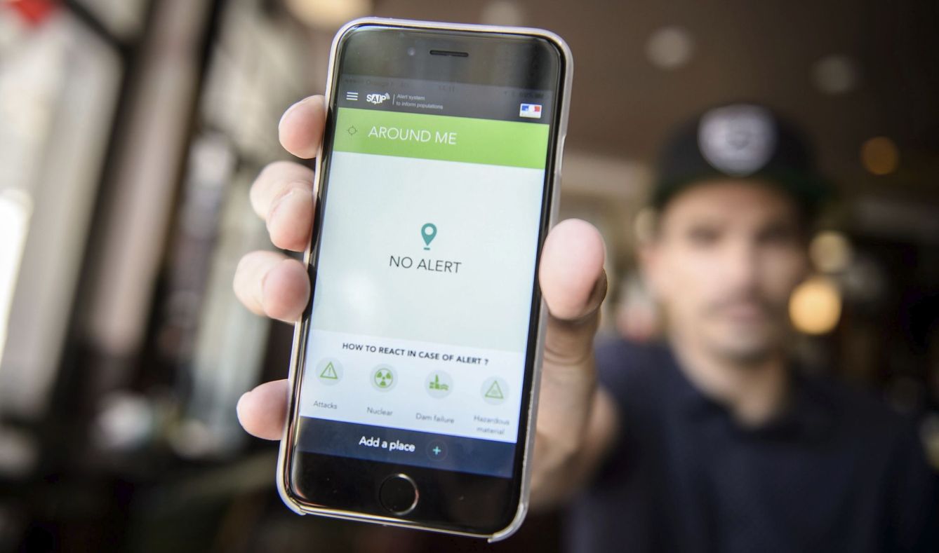 Un hombre muestra en su teléfono móvil la aplicación de Sistema de Alerta y de Información de la Población (SAIP) para la Eurocopa 2016 en París. (EFE)