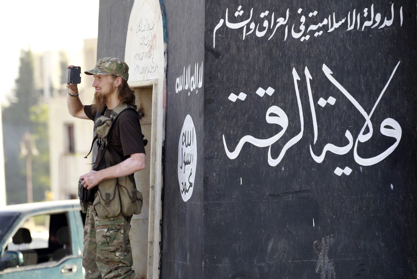 Un combatiente del ISIS graba con su móvil un desfile militar del grupo en Raqqa, Siria (Reuters).
