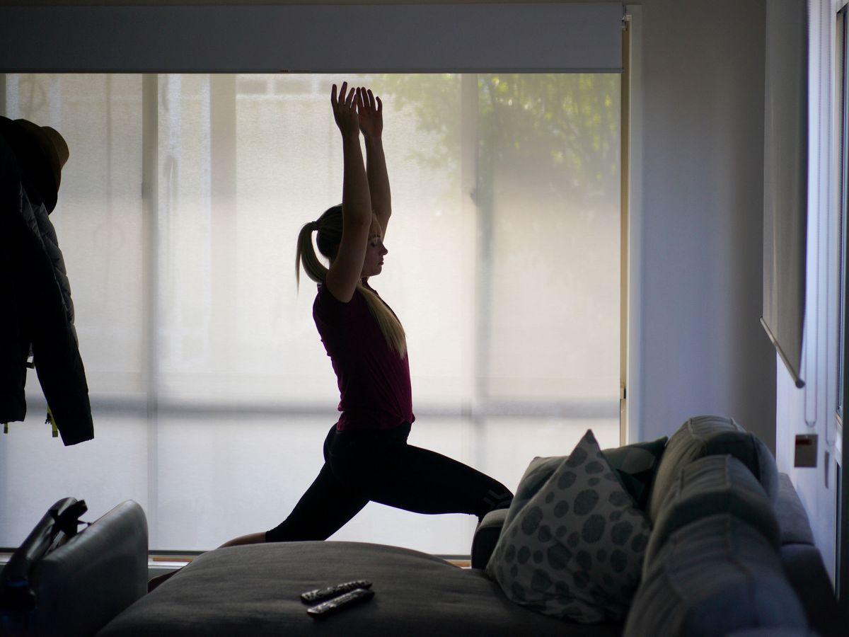 Foto: Una joven practica yoga en su casa. Foto: REUTERS Loren Elliott