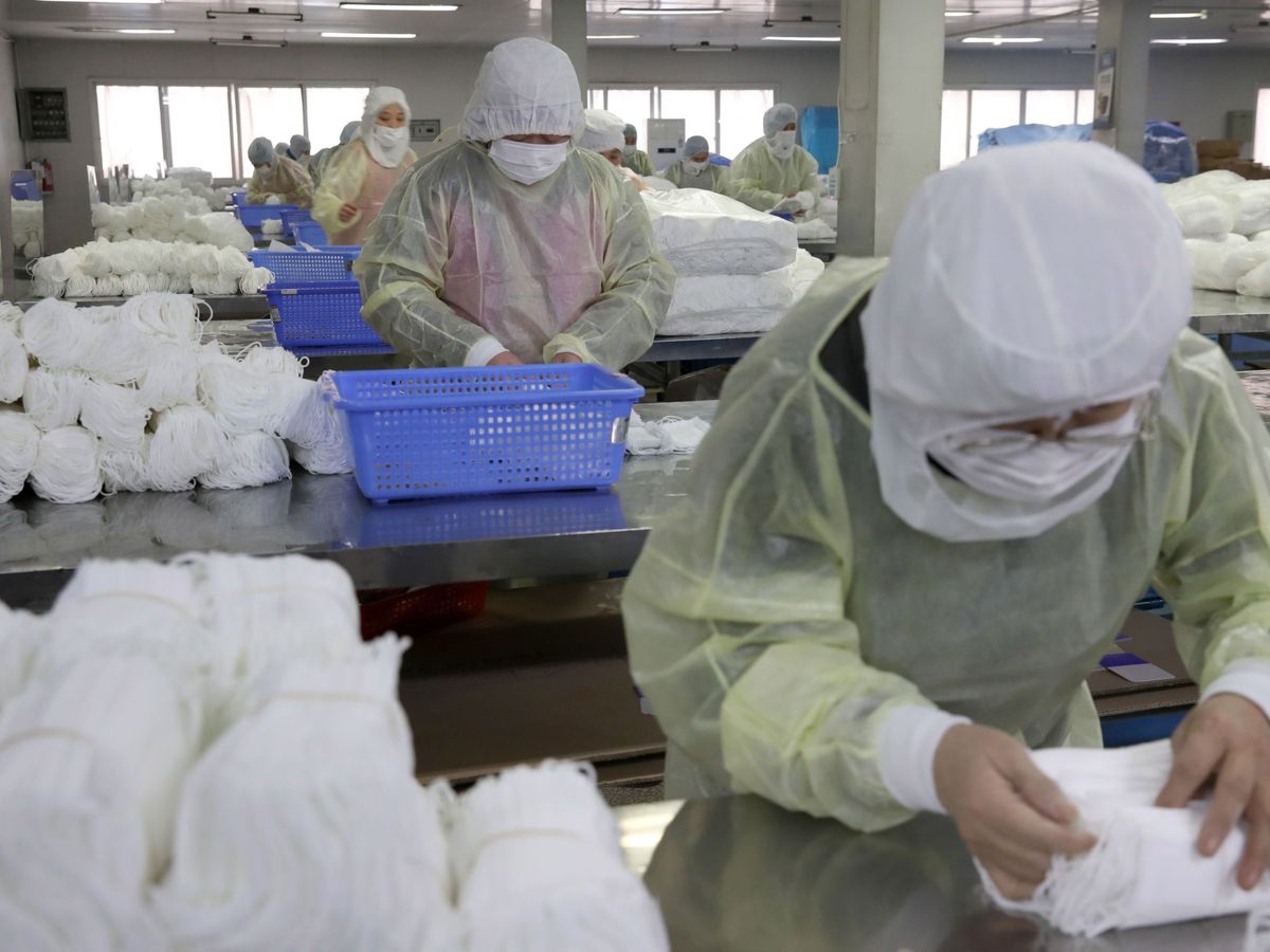Foto: Varias personas trabajan en una fábrica de mascarillas este lunes en Nantong (China). (EFE)