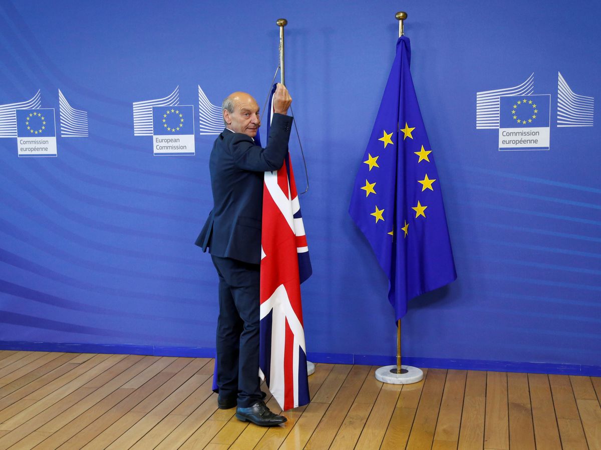 Foto: Un trabajador de la Comisión Europea retira la bandera británica. (Reuters)