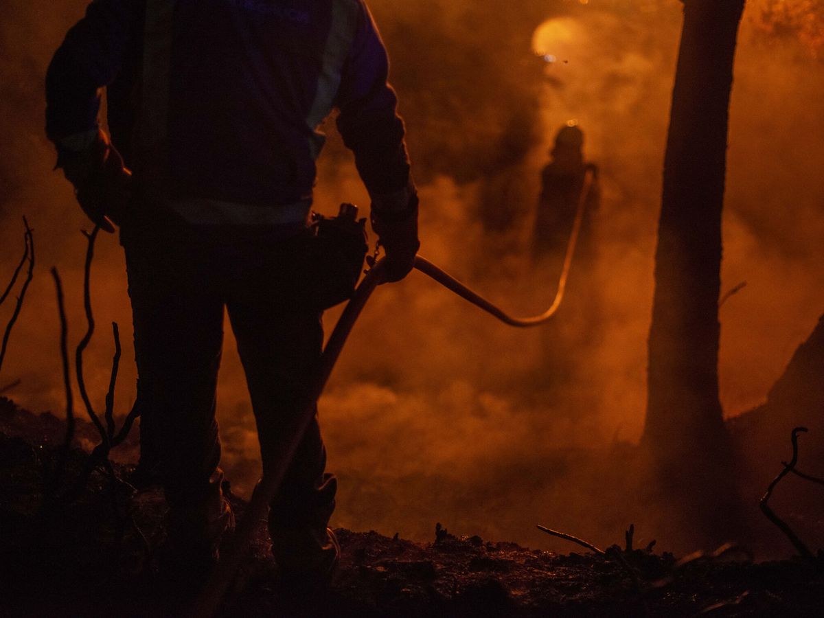 Foto: Los bomberos tratan de apagar las llamas en Castrelo de Miño (Ourense).  (EFE/Brais Lorenzo)