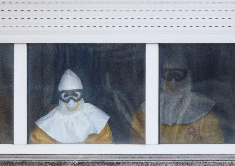 Foto: Sanitarios con el traje de protección se asoman a una ventana de la sexta planta del Carlos III. (Reuters)