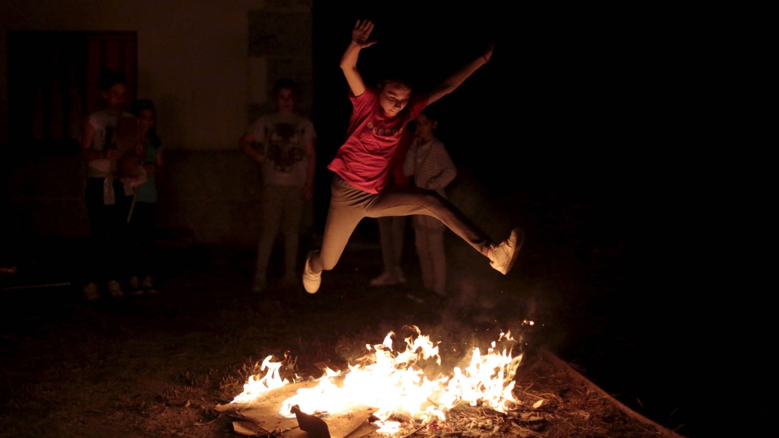 Foto: Una niña salta la hoguera en la noche de San Juan.