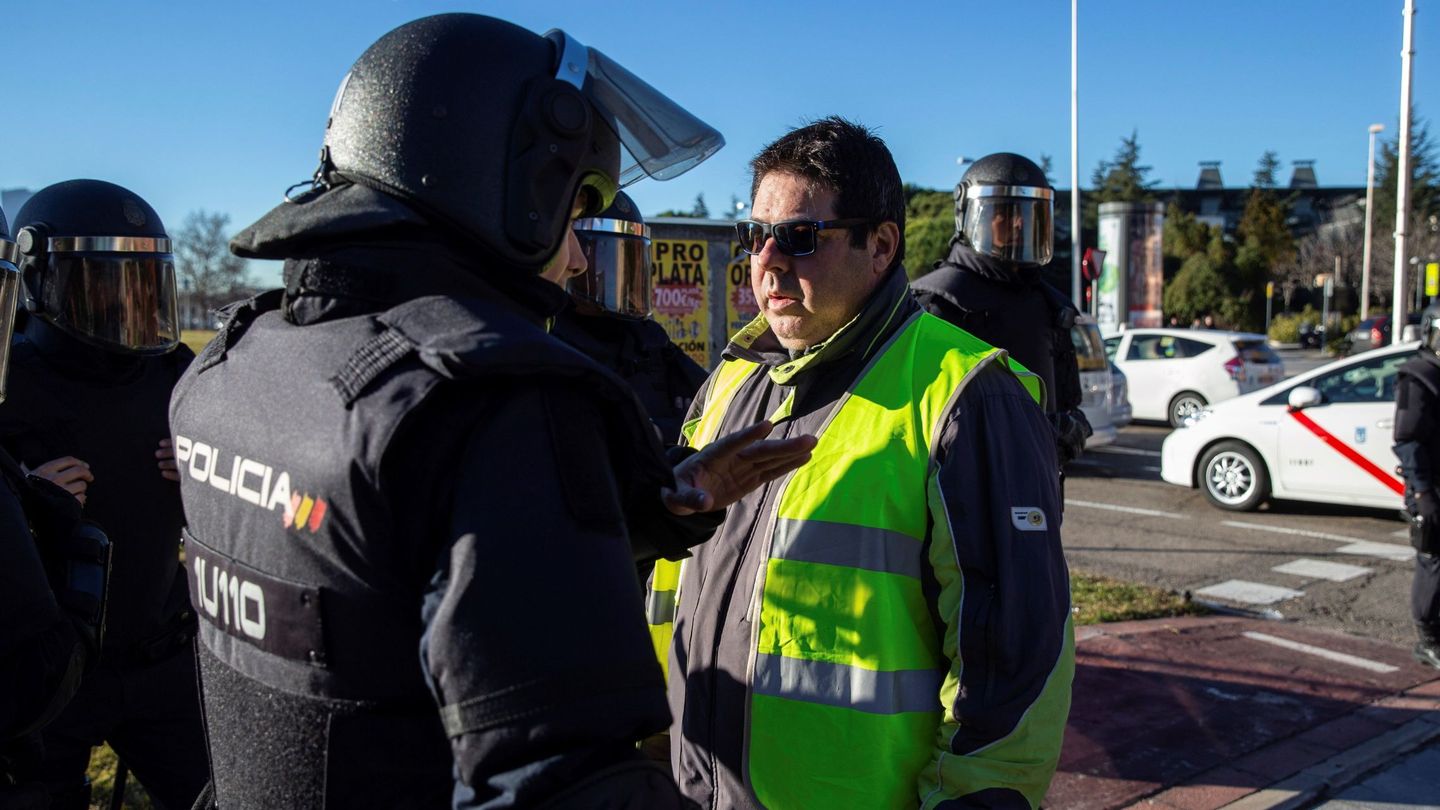 Un grupo de taxistas son bloqueados por las fuerzas de seguridad ante el intento de bloquear la M-40 en Madrid, en Ifema. (EFE)