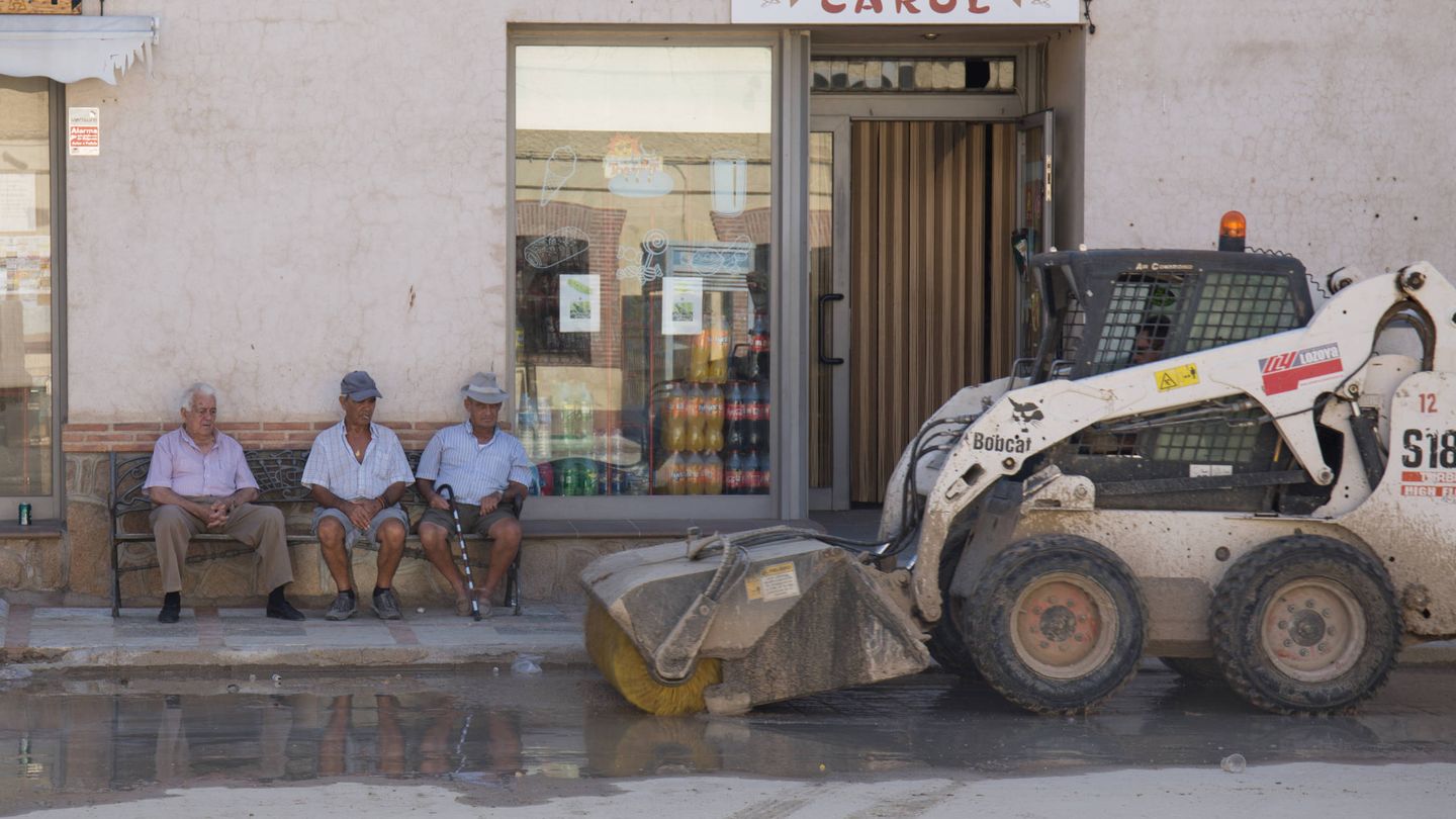 Vecinos de Cebolla contemplan los trabajos de limpieza en la calle Real. (D. B.)
