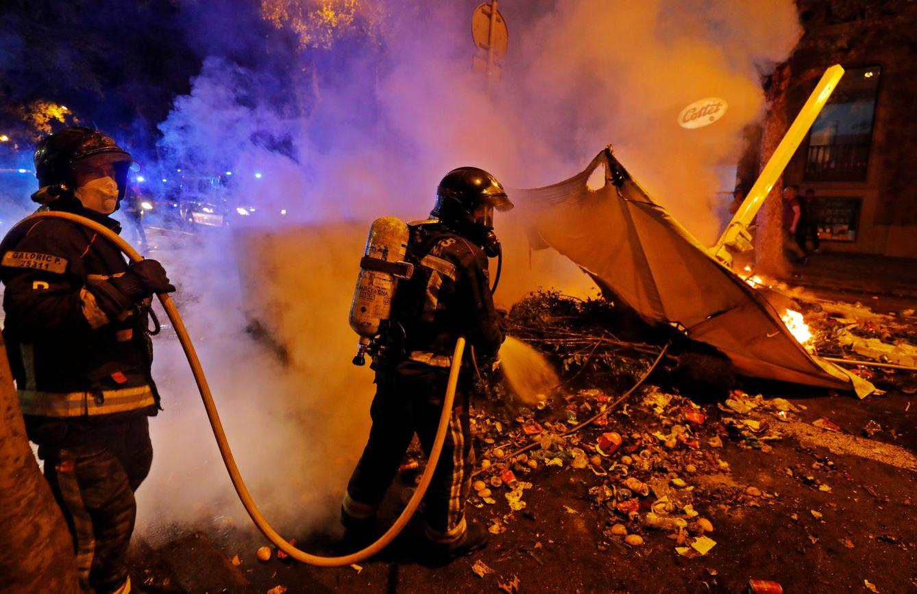 Los bomberos apagan una barricada la pasada noche en Barcelona. (Reuters)