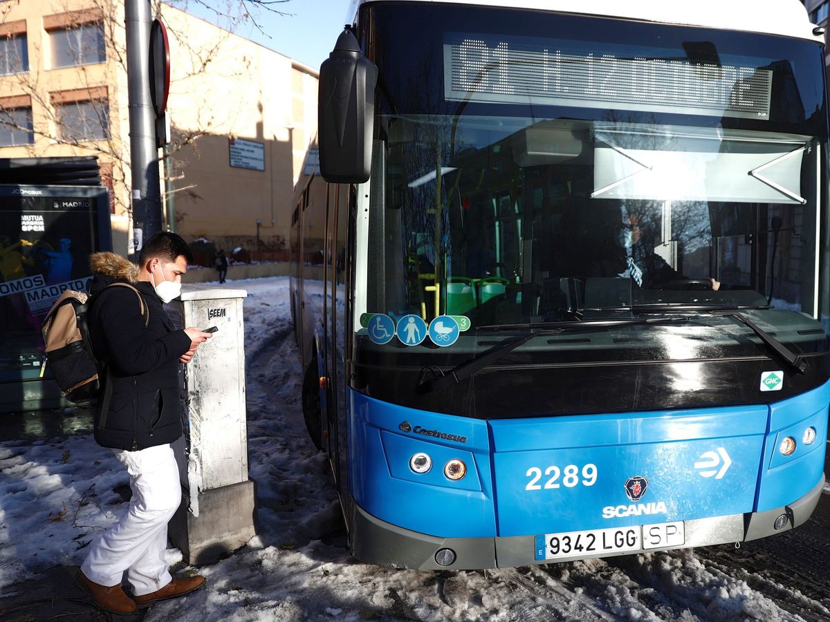 Foto: Un pasajero espera para coger el autobús en una parada tras la nevada (EFE)