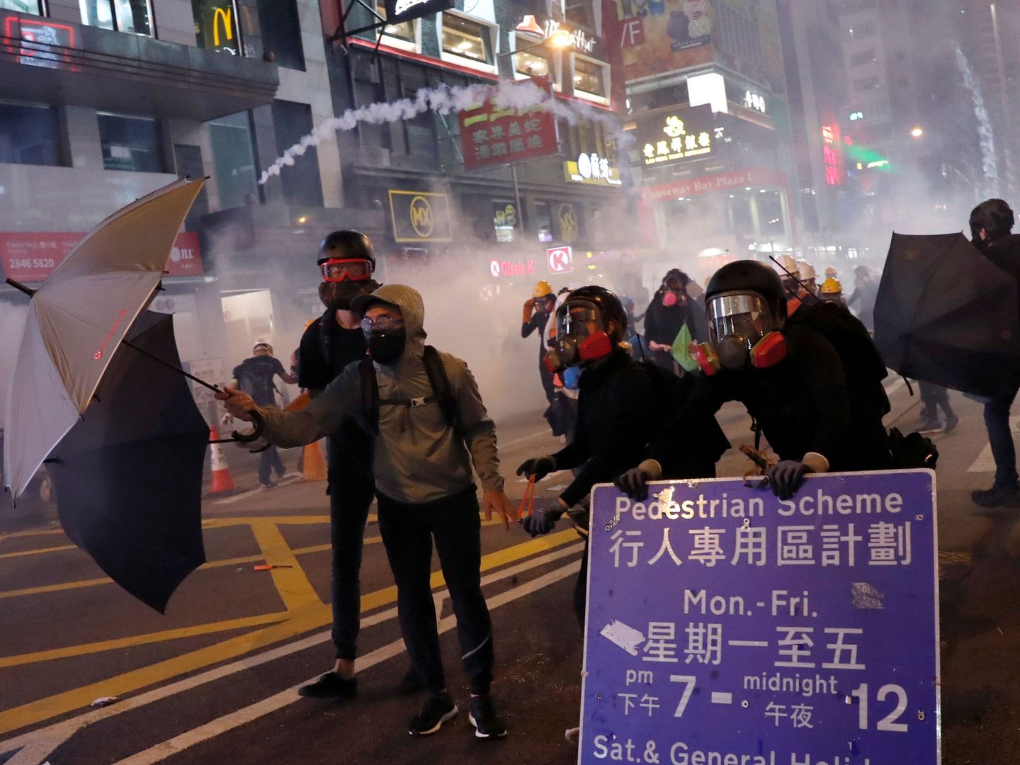 Protestantes protegiéndose del gas lacrimógeno de la policía de Hong Kong.(EFE)