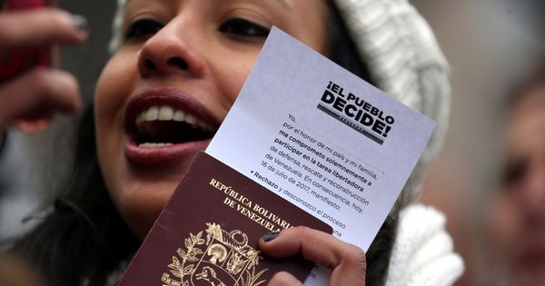 Foto: Una joven venezolana en Buenos Aires muestra su pasaporte tras votar en el plebiscito no oficial contra Maduro, el 16 de julio de 2017. (Reuters)