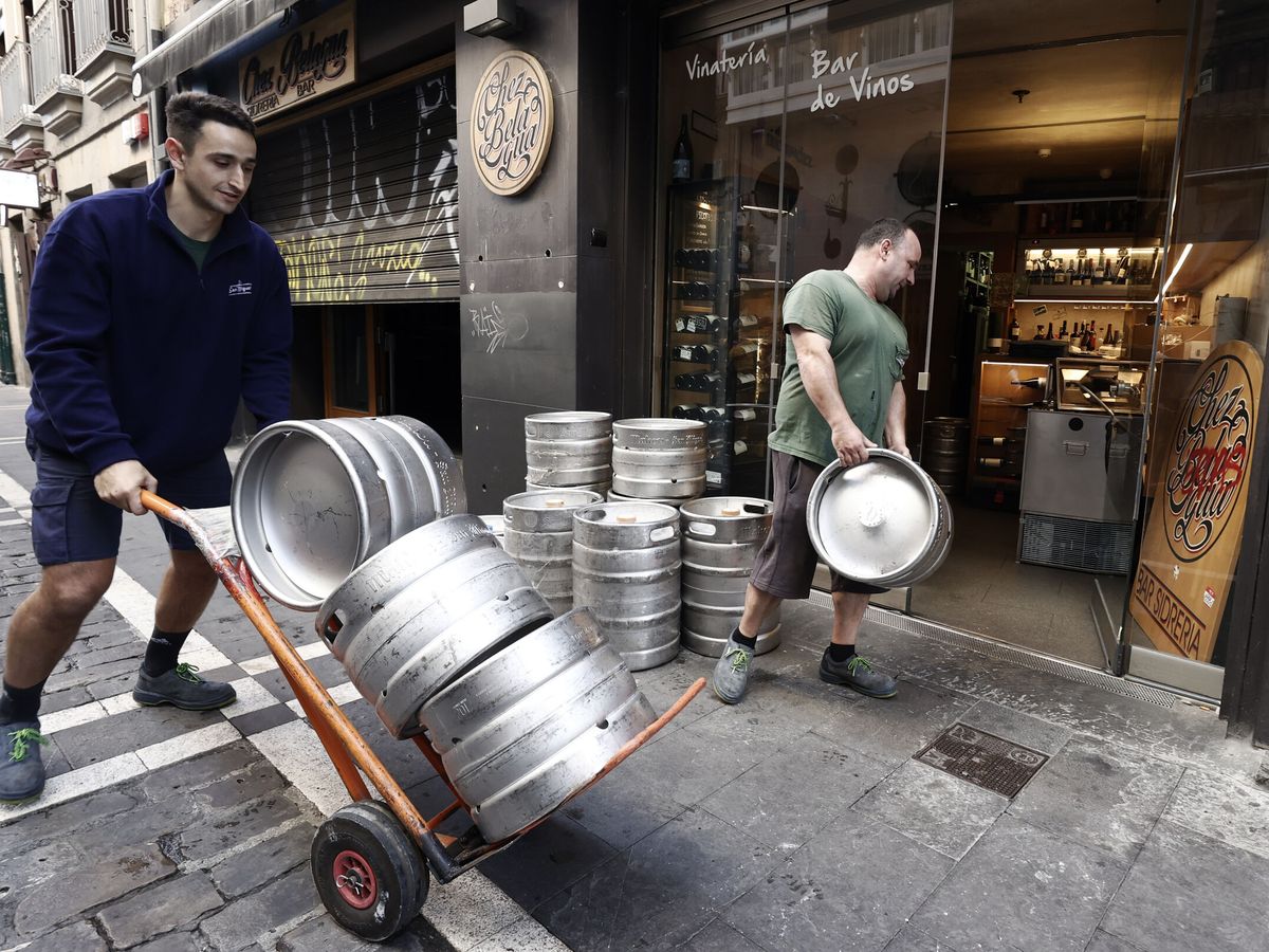 Foto: Dos trabajadores suministran bebida a un bar de Pamplona. (EFE/Jesús Diges)