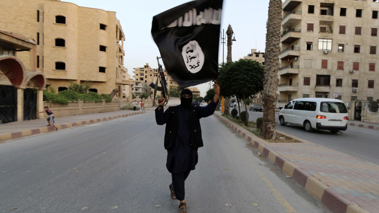 Foto: Un miembro del ISIS, con una bandera en Raqa (Reuters).