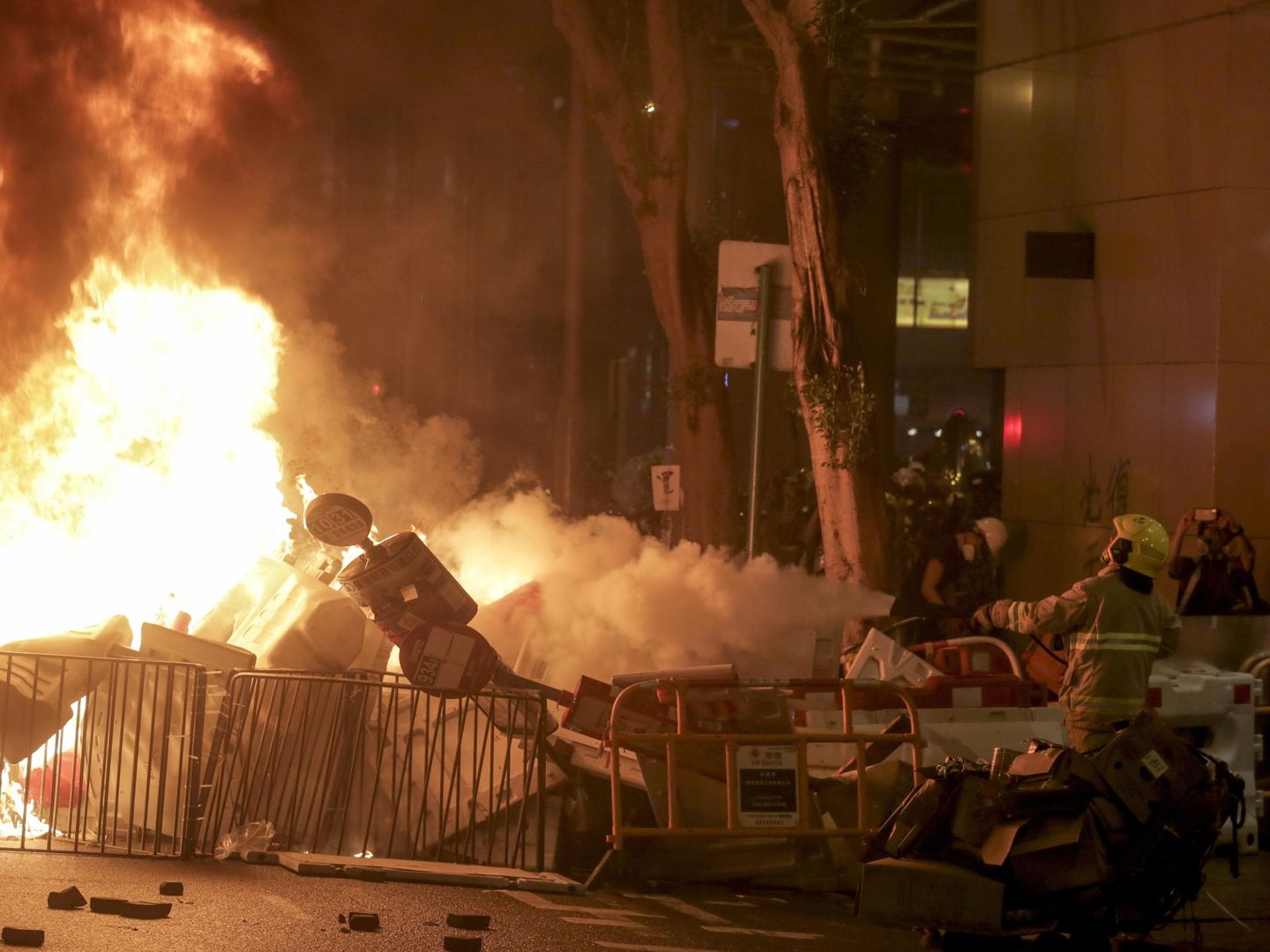 Los bomberos tratan de apagar una barrera improvisada incendiada durante la manifestación. (Reuters)