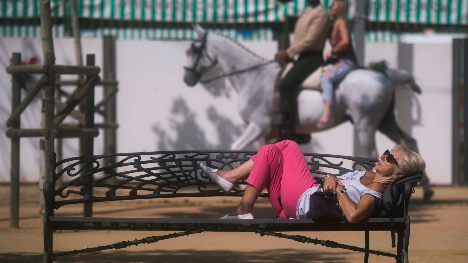 Foto: Una mujer echa un sueñecito en un banco de la feria de Córdoba. (EFE)