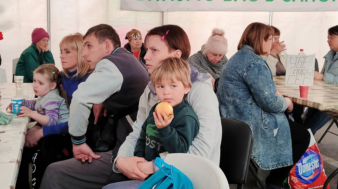 Un niños come una manzana en el centro de evacuados de Zaporiyia. (KAP)